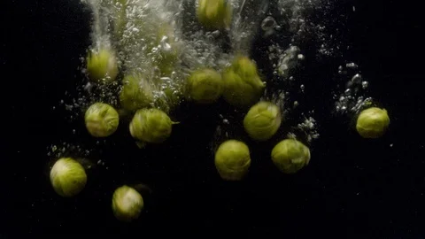 Brussels sprouts falling into the water with a splash and bubbles Stock Footage 123704591