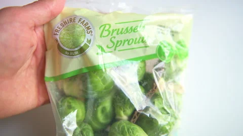 Brussels sprouts raw uncooked cabbage food in Aldi plastic bag closeup Video stock 316496558