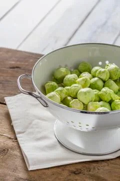 Brussels sprouts in a sieve on a table Stock Photos