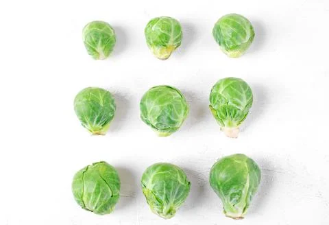 Brussels sprouts in three rows increasing in size on white Foto stock