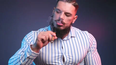 Brutal and handsome bodybuilder with beard and moustache smoking cigar in dark Stock Footage 146458374