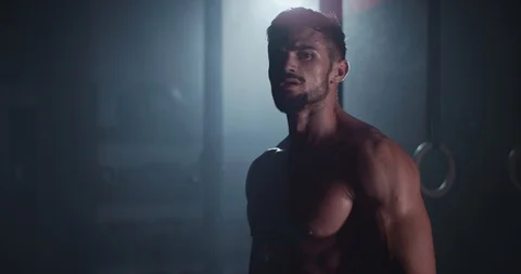 Brutal attractive athletic guy looking straight to the camera while doing his Stock Footage 118604330