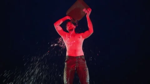 Brutal cool man drench himself with gas using canister in red light Stock Footage 144671978