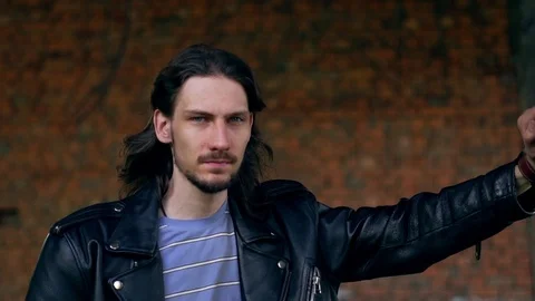 Brutal guy in a leather jacket in an old house Stock Footage 115564711