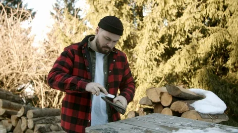 Brutal lumberjack neatly sharpens a blunt ax Stock Footage 123523469