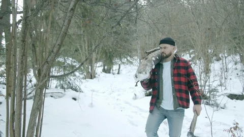 Brutal lumberjack walks through the winter forest Stock Footage 123523616