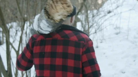 Brutal lumberjack walks through the winter forest Stock Footage 123524650