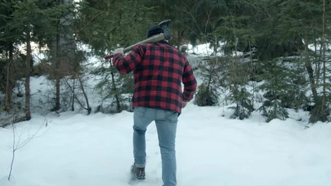 Brutal lumberjack walks through the winter forest Video stock 123529347
