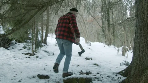 Brutal lumberjack walks through the winter forest Stock Footage 123529523