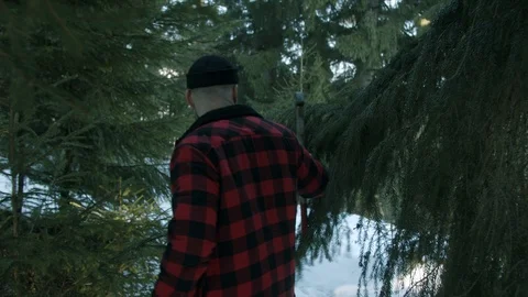 Brutal lumberjack walks through the winter forest Stock Footage 123530789