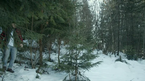 Brutal lumberjack walks through the winter forest Stock Footage 123530937