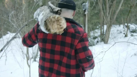Brutal lumberjack walks through the winter forest Stock Footage 123531935