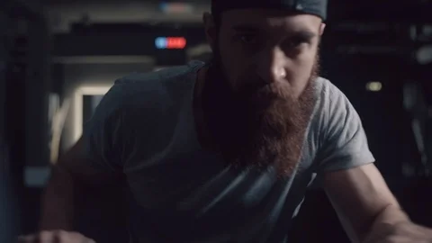 Brutal man with a beard intensively moving his hands on the ellipsoid Stock Footage 90642260