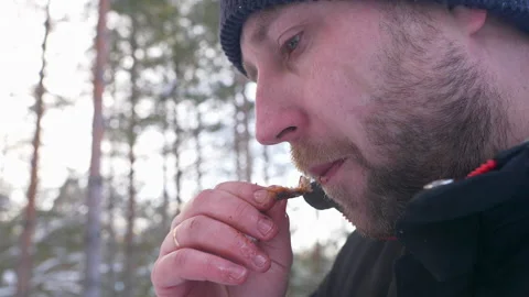 Brutal man with bristles eats quail meat on the street close-up Video stock 172503206