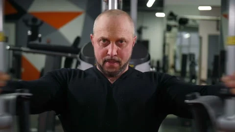 Brutal man is engaged on the simulator. Opens his arms to the sides and Stock-Footage 100261424