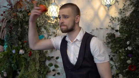 Brutal man picked up bitten red apple from floor throws it behind him, sad Stockbeeldmateriaal 129093218