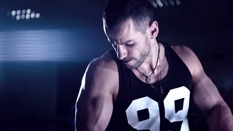 Brutal man shakes his biceps in the gym Stock Footage