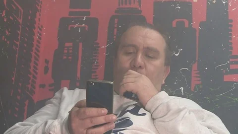 Brutal man typing a message on the phone and vaping Stockbeeldmateriaal 71989900