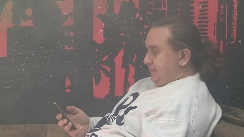 Brutal man typing a message on the phone and vaping Stock Footage 72139402