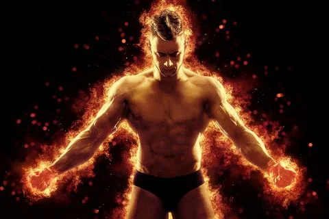 Brutal strong athletic Bodybuilder posing. Fire and spark explosion in the Stock Photos