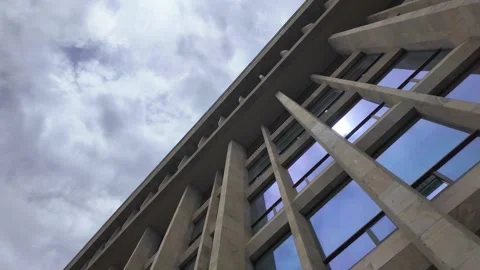 Brutalist concrete building facade with reflective windows Stock Footage 337645984