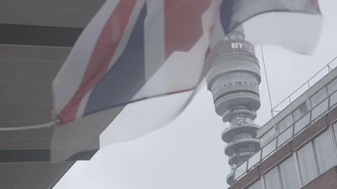 BT Tower Framed Behind Waving Union Jack Flag in London Stock Footage 342565911