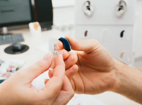 BTE hearing aid close-up in e hand. Hearing solution, hearing aid, macro Foto stock
