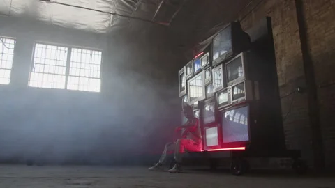 BTS of Artis Sitting By Stack Of TV's Stock Footage 270327118