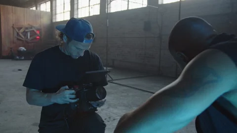 BTS Of Camera Man Taking Shot Of Artist Sitting By Static TV's Stock Footage 270331226