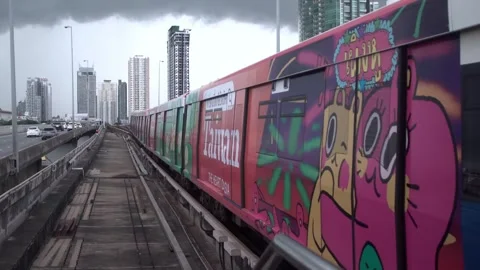 BTS Sky Train on rail tracks above traffic in city. Stock Footage 250418551