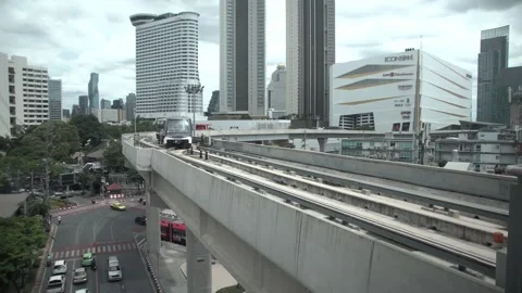 BTS Sky Train on rail tracks above traffic in city. Stock Footage 250425488