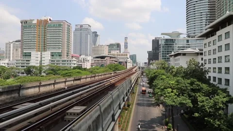 BTS Skytrain in Bangkok, passing train in the background of the city. Video stock 130185759