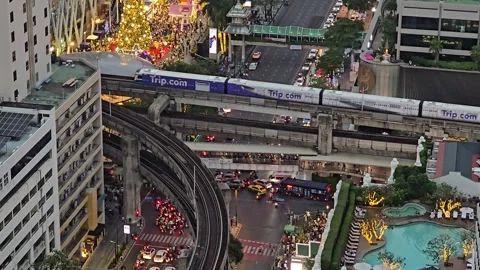 BTS Skytrain Passing Intersection at Erawan Shrine in Central Bangkok Overhead Видео 331702070