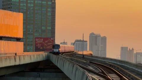 BTS Skytrain Traveling Into Distance on Elevated Tracks at Golden Hour Stock Footage 345512369