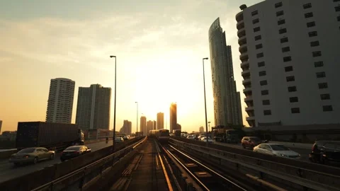 BTS Train Moving During Beautiful Golden Sunset with Big City Buildings on Stock Footage 243549274