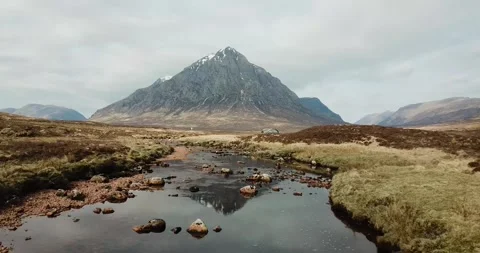 Buachaille Etive Mor reflection in River Coe aerial panning backwards 库存影片 152486640