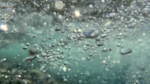Bubble clusters rise and scatter through churning seawater, shaped by forceful Video stock 314119767