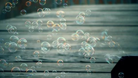 Bubble machine producing colorful soap bubbles in sunlight Stock Photos