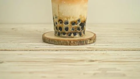 Bubble tea in a glass with tapioca pearls on a wooden surface Stock Photos