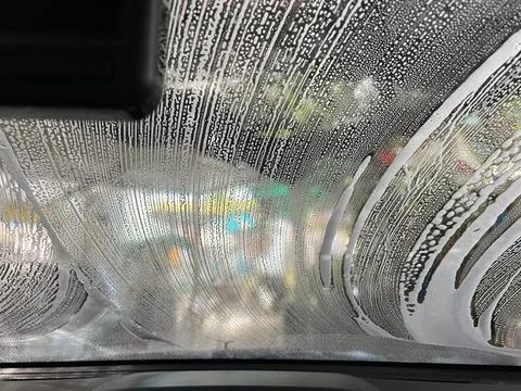 Bubble water on the windshield for cleaning. Stock Photos