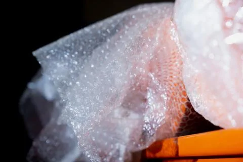 Bubble wrap packaging covering orange industrial part Stock Photos