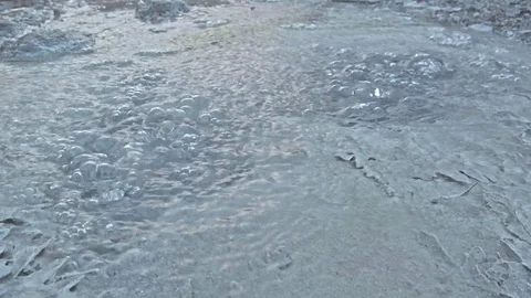 Bubbles of air come out one after another from a source of pure thermal water Stock Footage 125585814