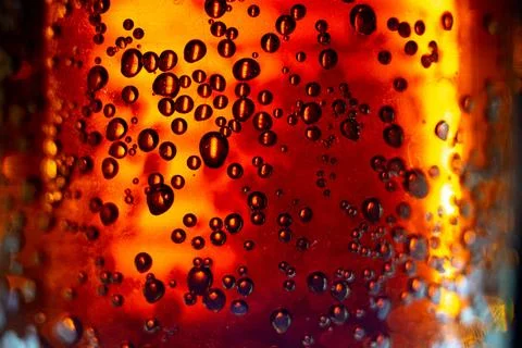 Bubbles in amber liquid with warm glowing light and golden bokeh effect Stock Photos