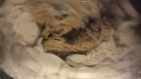 Bubbles and fabric dance in the washing machine during laundry time 스톡 동영상 316681631