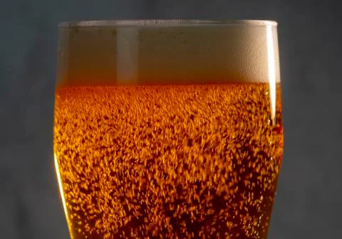 Bubbles and foam in the rays of light in a glass of beer close-up Foto stock