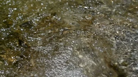 Bubbles and sunlight effects on flowing water of a mountain river (slow motion) Video stock 212749079