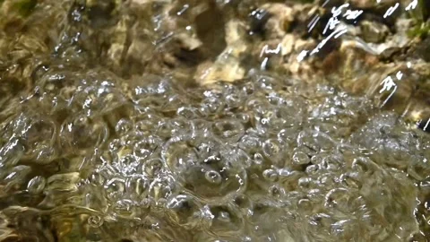 Bubbles and sunlight effects on a mountain river (slow motion) Video stock 212766078