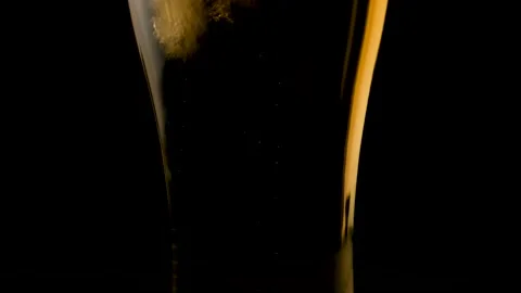Bubbles in a beer glass. Close up. Slow motion. Black background. Stock Footage 135123134