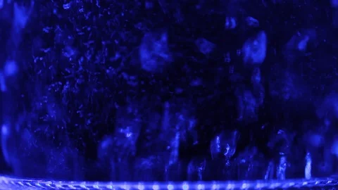 Bubbles of boiling water in an electric kettle in the dark. Close-up Stock Footage 87428378