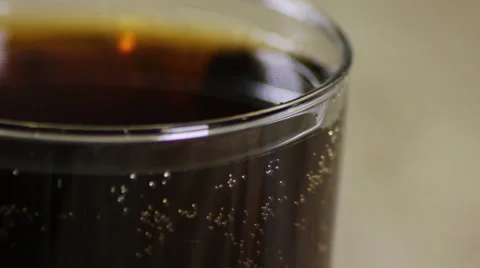 Bubbles of cabonation rising to the surface in a glass of soda Stock Footage 61960220